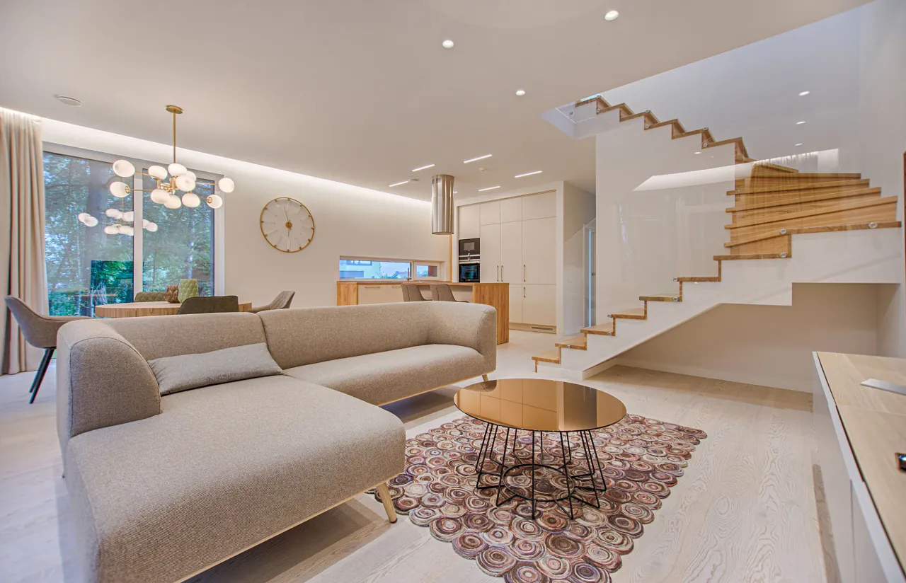 Heller Wohnbereich mit Sofa und offener Treppe, Beispielfoto